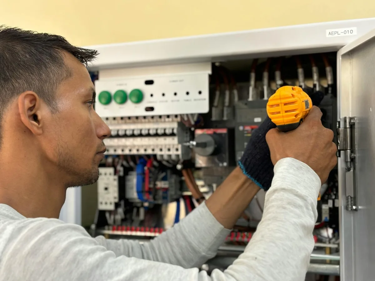 électricien professionnel travaillant sur un tableau électrique à Machecoul